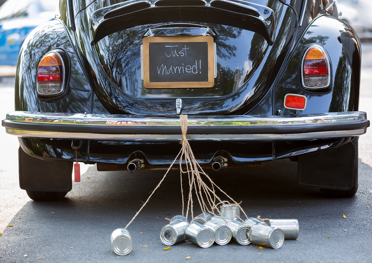 Rear view of a vintage car with just married sign and cans attac