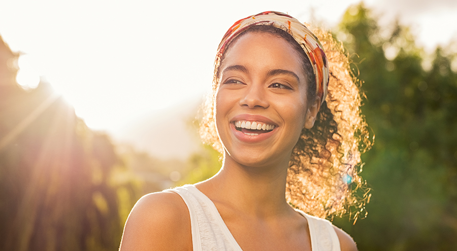 Young african woman smiling at sunset
